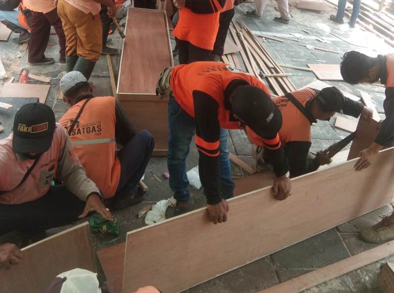 Proses pengerjaan peti mati di lingkungan Pemkot Surabaya.