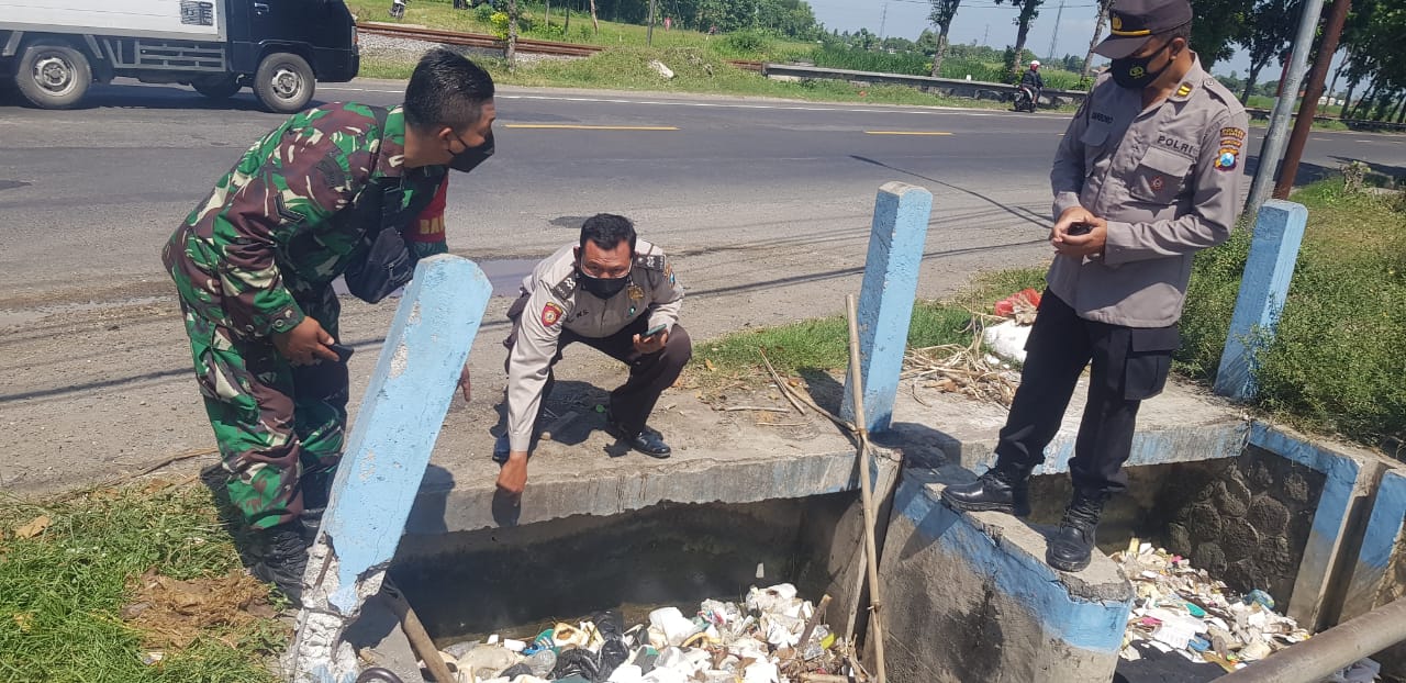 Petugas saat evakuasi dua mayat bayi di aliran sungai.