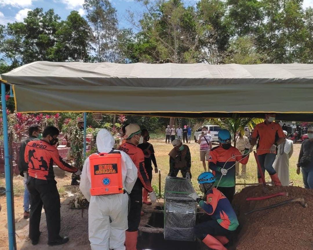 Satu regu tim pemakaman dari Satbrimob Polda Kalsel saat melaksanakan pemakaman jenazah pasien COVID-19.