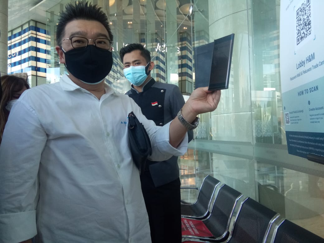 Ketua Asosiasi Pengelola Pusat Belanja Indonesia (APPBI) Jatim, Sutandi Purnomosidi saat menunjukkan cara scand barcode dipintu masuk Pakuwon Mall Kota Surabaya.