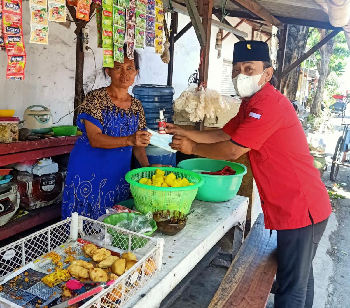 Suasana kader PDIP Surabaya membagikan masker dan hand sanitazer kepada warga, Rabu (11/8/2021).
