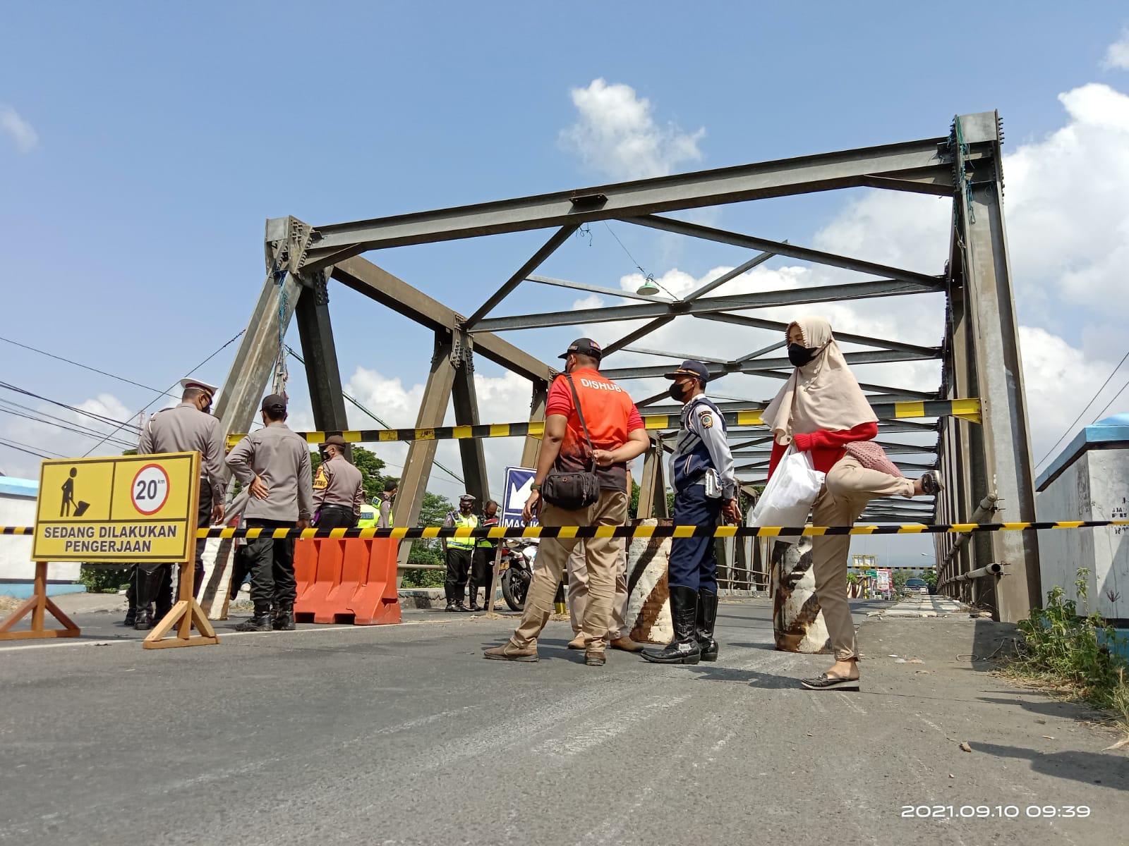 Warga melompati pita garis pembatas jembatan Karangrejo dengan berjalan kaki.