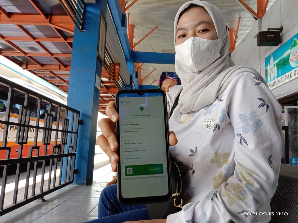 Calon penumpang di Terminal Gayatri, Donna tunjukan aplikasi peduli lindungi miliknya.(Joko Pramono for BACASJA.ID)