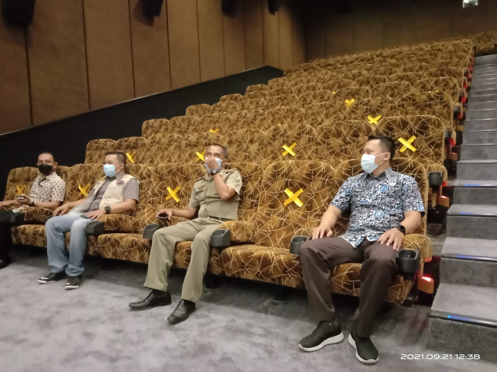 Sepi, seorang karyawan gedung bioskop menjaga pintu masuk.