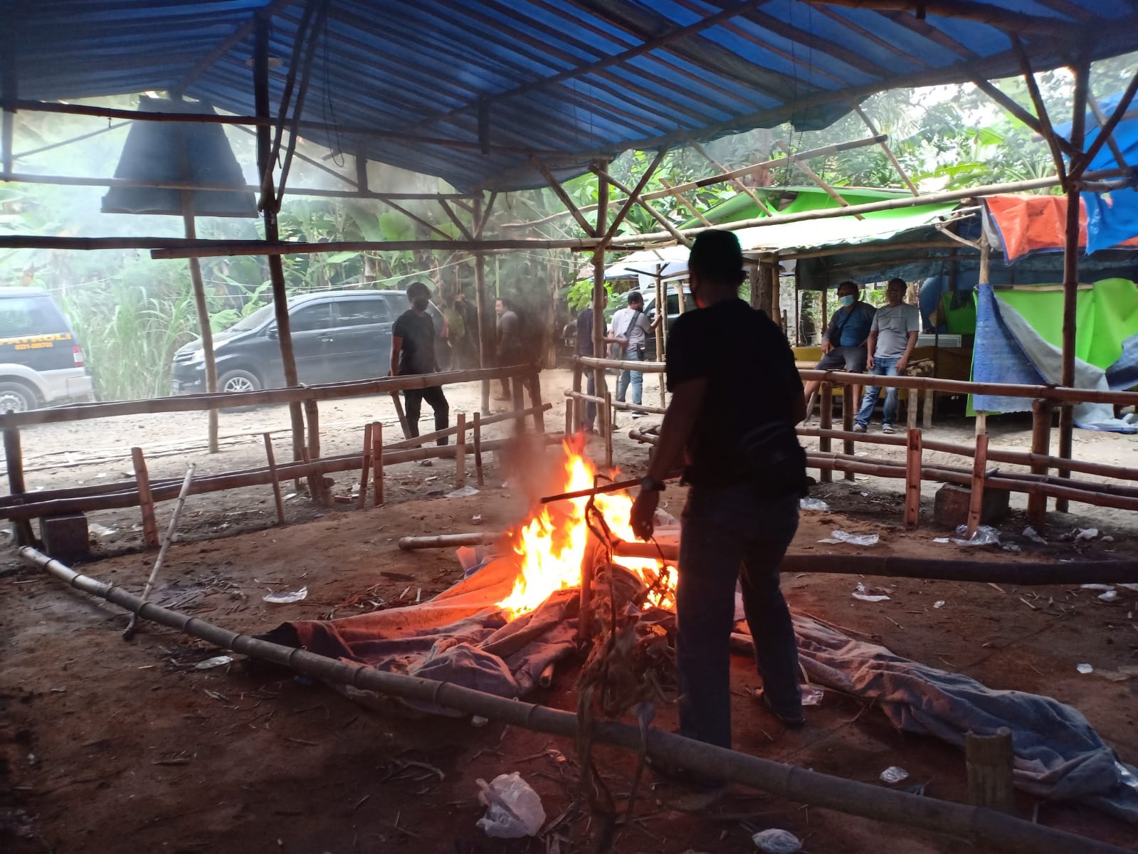 Anggota Polisi saat membakar tempat arena perjudian di Jombang.