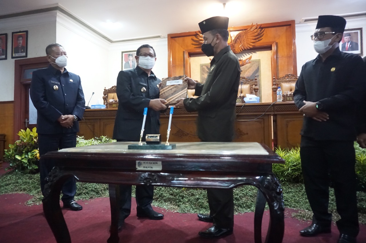 Ketua DPRD Kabupaten Tulungagung, Marsono (Kanan) serahkan Perda APBD Tulungagung tahun 2022 pada Bupati Tulungagung, Maryoto Birowo.
