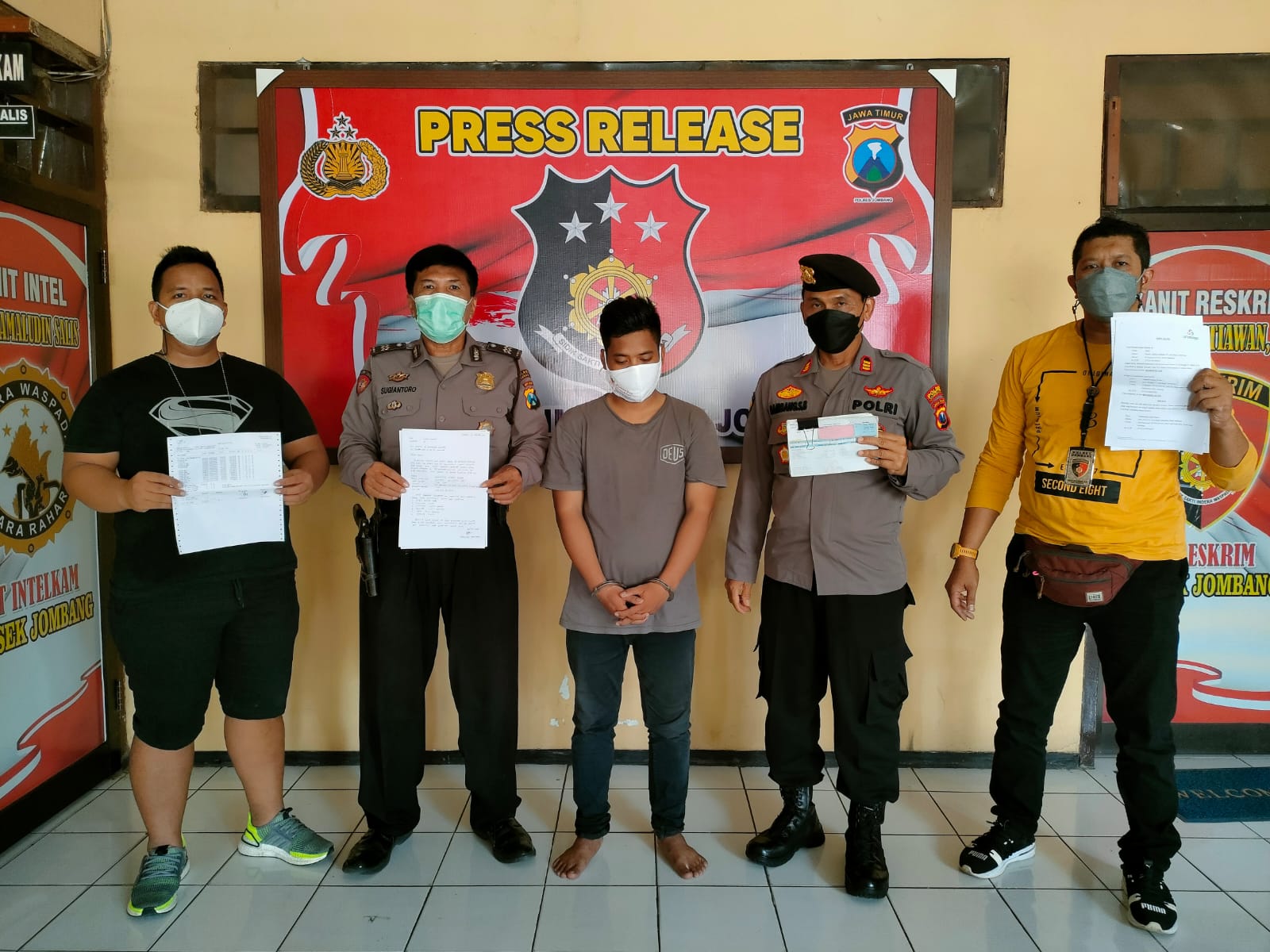 Pelaku penggelapan diapit petugas Unit Reskrim Polsek Jombang Kota.