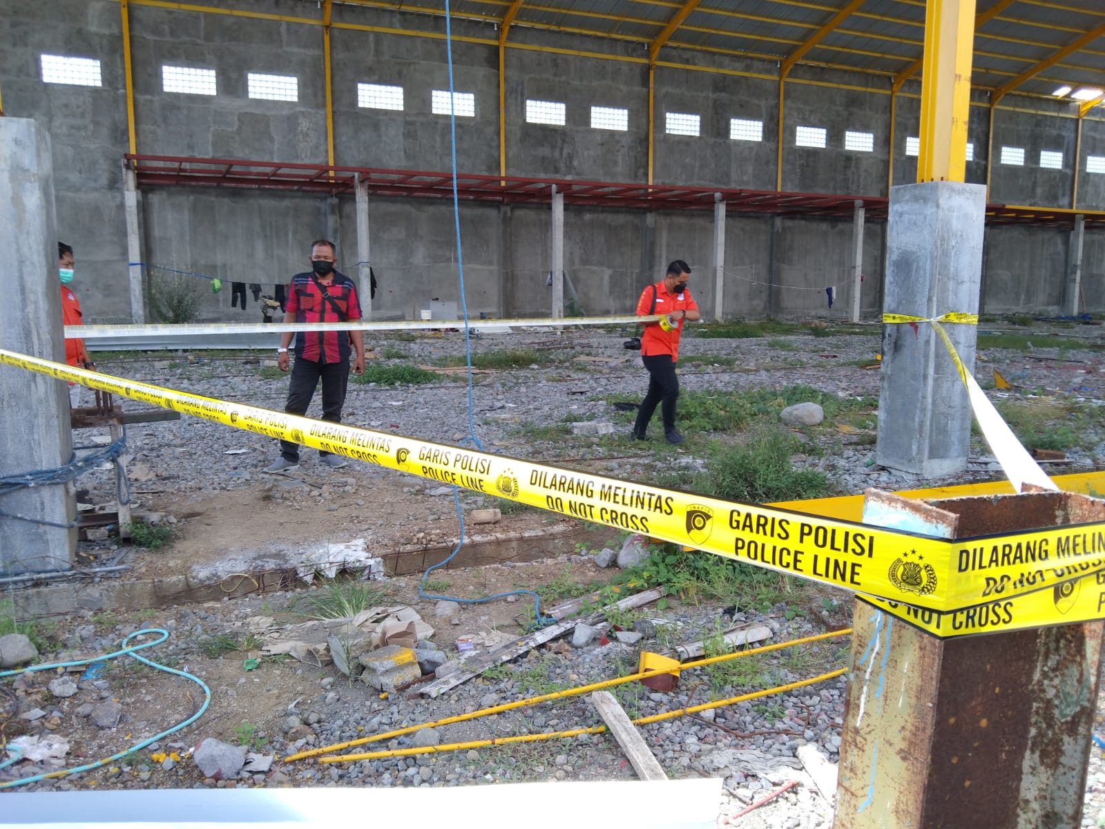 Petugas saat memasang garis polisi di lokasi jatuhnya korban.