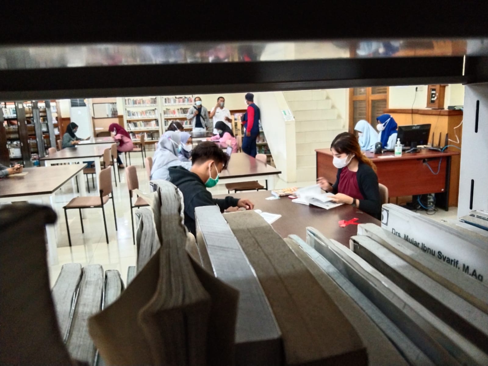 Pengunjung perpustakaan sedang membaca buku.