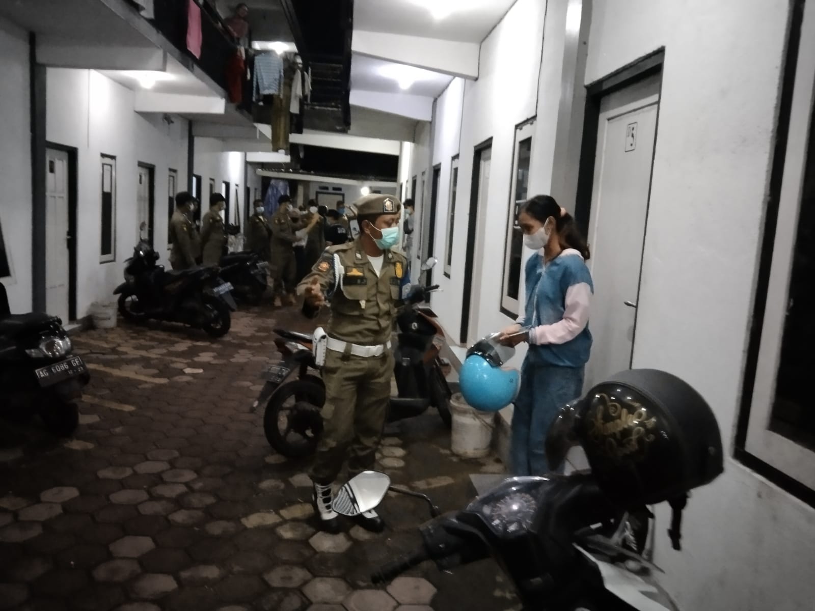 memanjat, petugas memanjat sepeda motor mengintip kamar kos yang diduga ada penghuninya.
