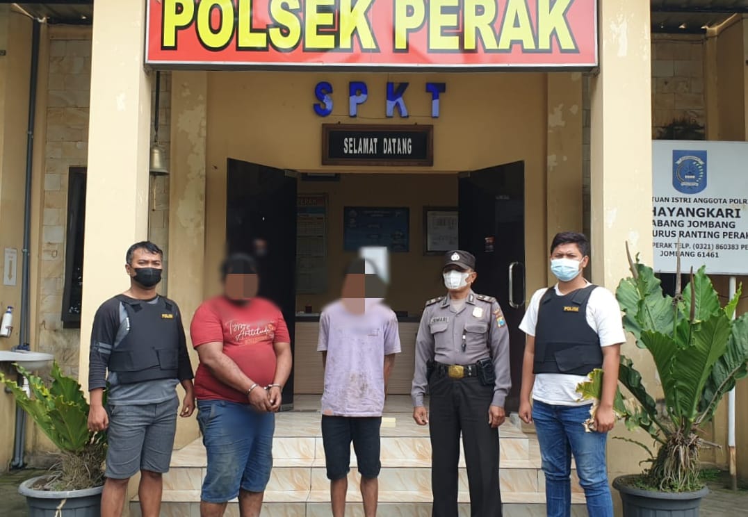 Dua pelaku pencurian tiang telpon diapit petugas.