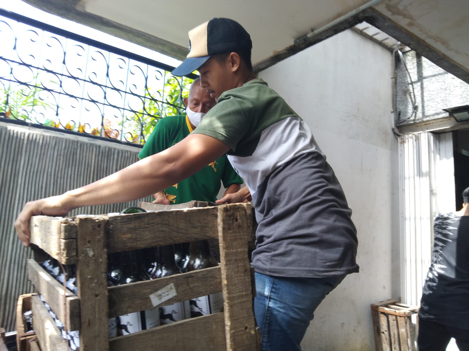 Karyawan pabrik kecap kuda saat menaikan botol kecap ke atas mobil terbuka