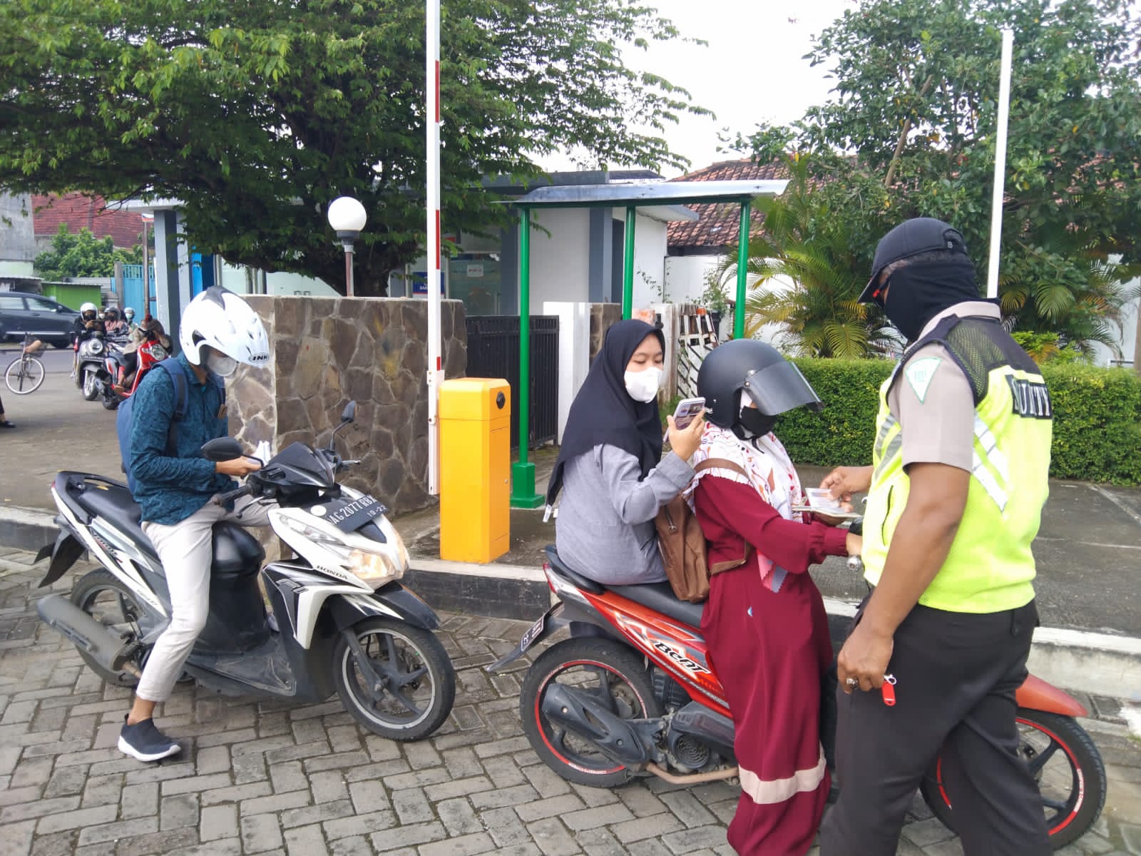 Mahasiswa antri masuk kedalam area kampus, sambil menunjukan bukti vaksin.