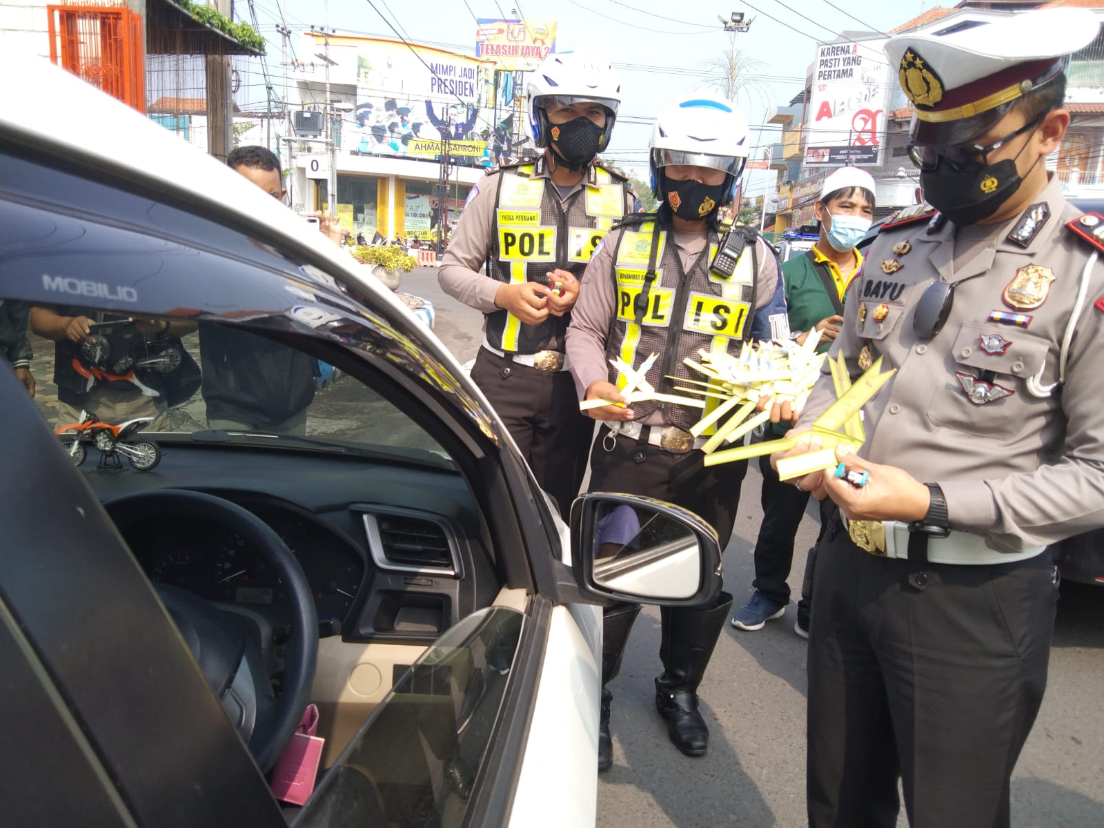 Kasat Lantas Polres Tulungagung, AKP Muhammad Bayu Agustyan memasang janur kuning di kendaraan yang melanggar lalu lintas.