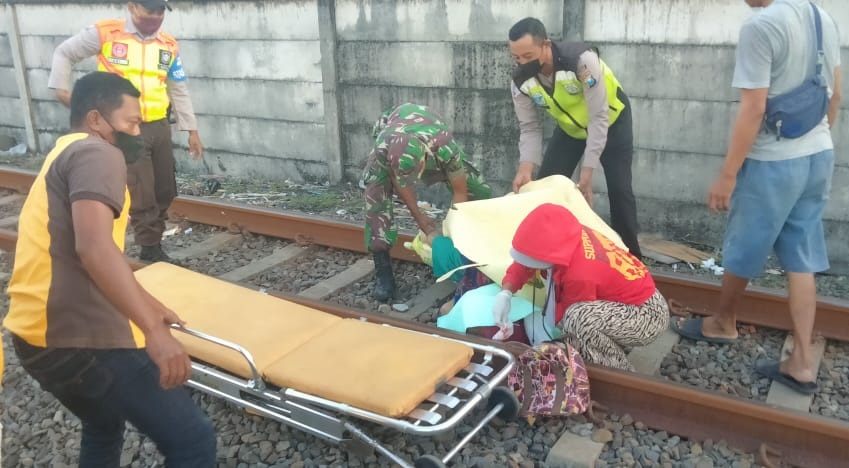 petugas mengevakuasi korban di perlintasan kereta api.