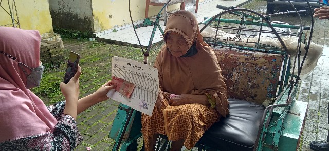 Warga lansia menerima BPNT diatas becak karena sakit. 
