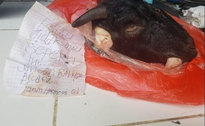 Sebuah kepala kambing dan secarik kertas bertuliskan ancaman terletak di teras rumah Ketua KIPP Jatim. ( foto: redaksi ) 