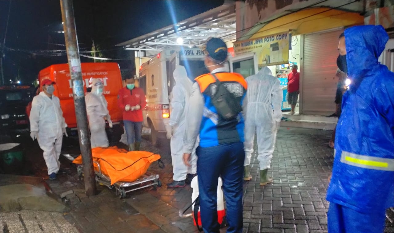 Petugas saat melakukan evakuasi jenazah yang meninggal di kamar, (Istimewa) 