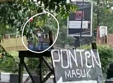 Tangkapan layar video 'bajing loncat' saat mengambil ban dan velg dari atas truk yang disebut-sebut melintas di wilayah Krian, Sidoarjo (IST)
