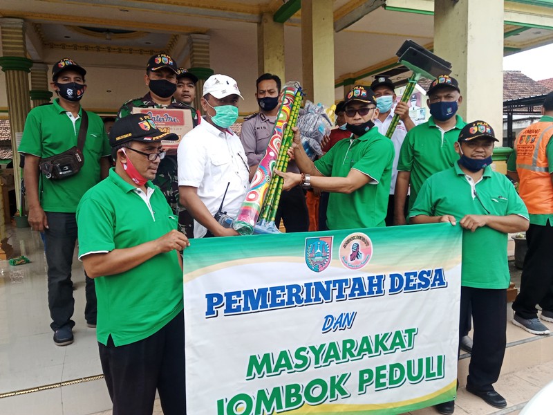 Kades Jombok menyerahkan bantuan kepada kepala Desa Bandarkedungmulyo, Kabupaten Jombang, Rabu (10/2/2021)