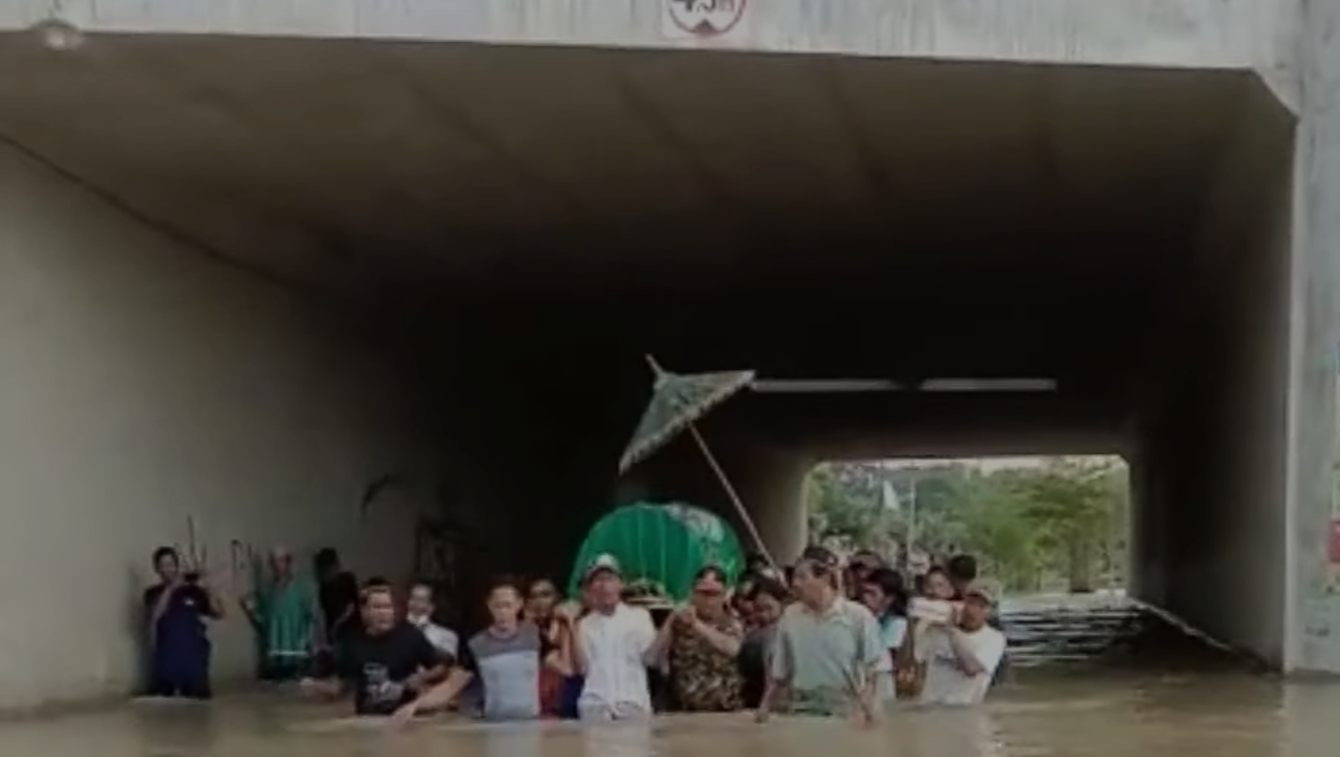 Warga Dusun Kedunggabus, Desa Bandarkedungmulyo, Kabupaten Jombang, Jawa Timur saat menerobos banjir sambil memikul keranda jenazah, Kamis (11/2/2021). | Jombang Channel