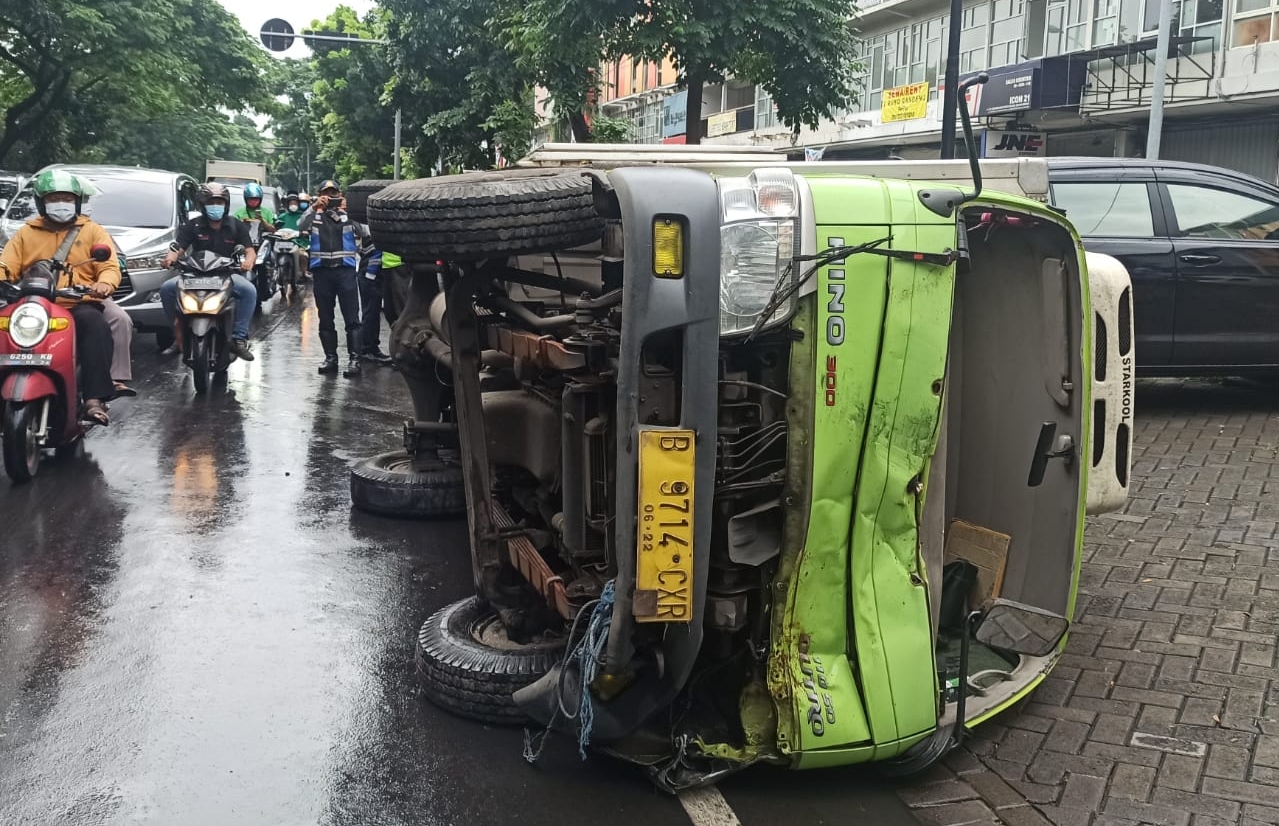 Truk terguling di Jalan Ir Soekarno-Hatta (MERR) Surabaya akibat putar balik dengan kecepatan tinggi saat kondisi jalan licin setelah diguyur hujan. (IST)