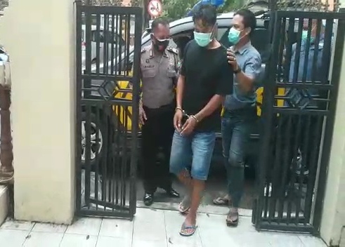 Imam Amsur (36), pelaku KDRT saat digelandang di Mapolsek Krian, Sidoarjo. 