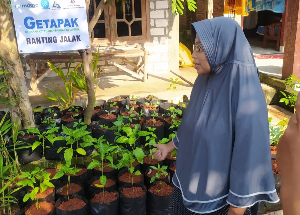 Tutik, di depan ruamh yang penuh tanaman cabai.