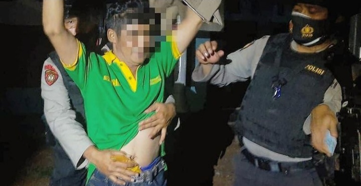 Anggota polisi menggeledah pria yang membawa senjata tajam saat digelar patroli malam di Banjarbaru, Kalsel. (Foto:Edi/Bacasaja.id)