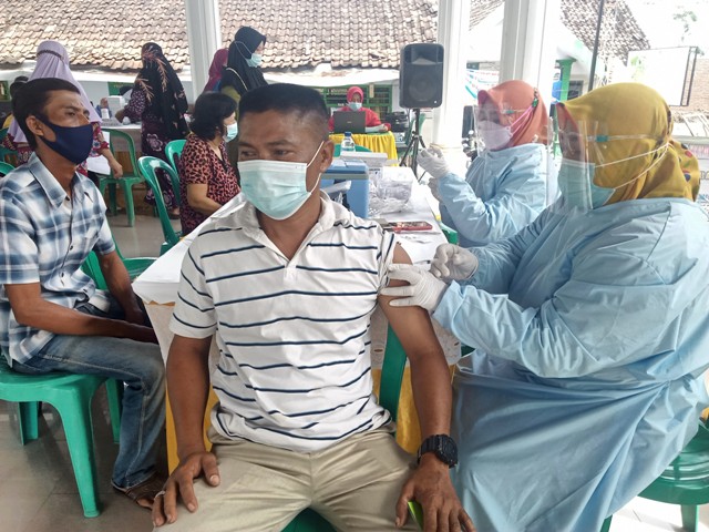 Petugas BLUD Puskesmas Kesamben Ngoro saat memberikan vaksin kepada warga.
