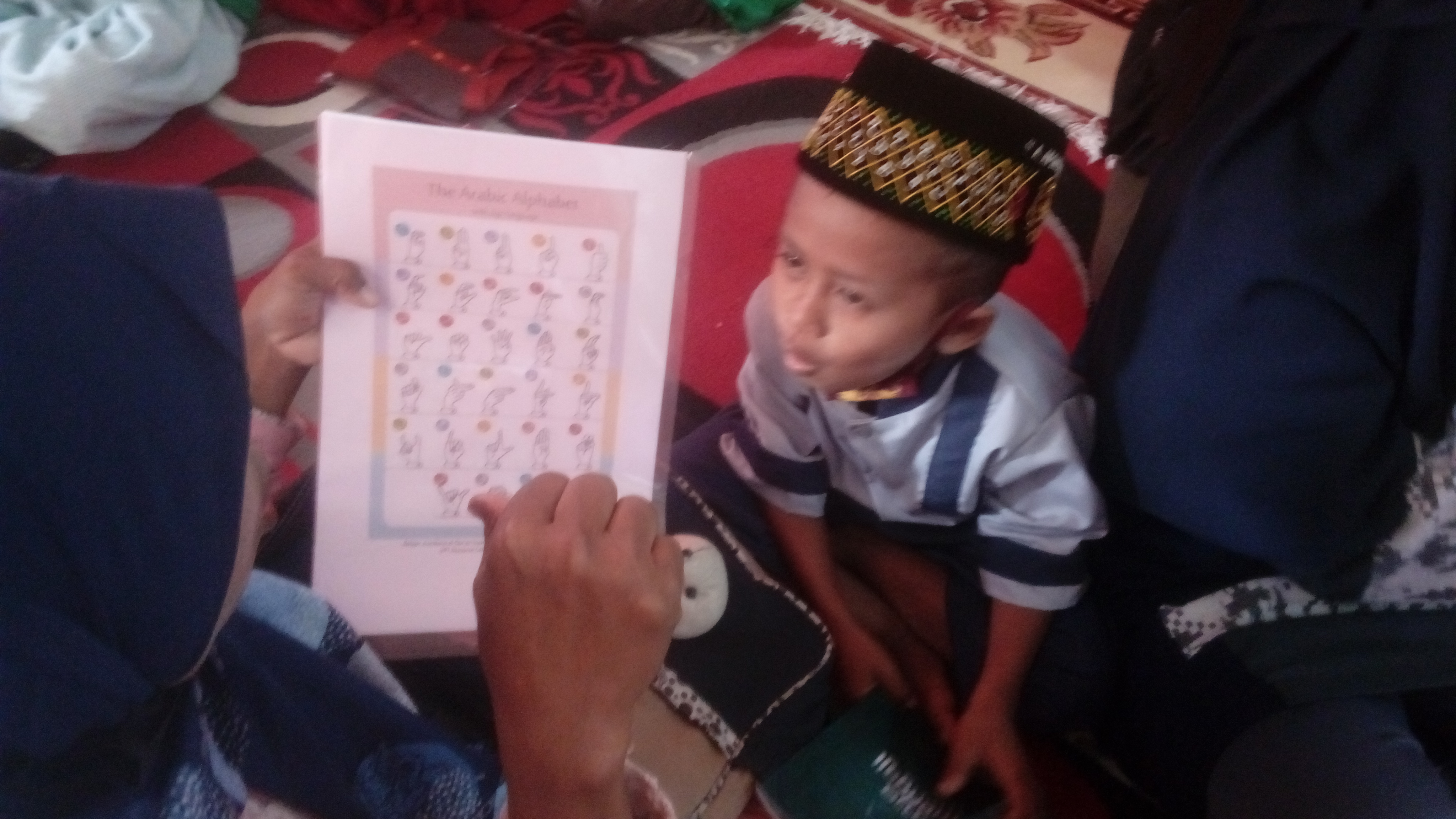 Kepala UPT Resource Center Gresik, Innik Hikmatin melatih siswa tunarungu dalam membaca Al-Quran dengan isyarat tangan. 