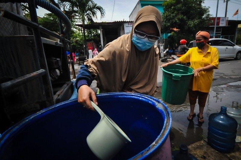 Warga mengambil air dari bak air di kawasan Surabaya barat, Jawa Timur, Sabtu (13/2/2021). | donz/bacasaja.id