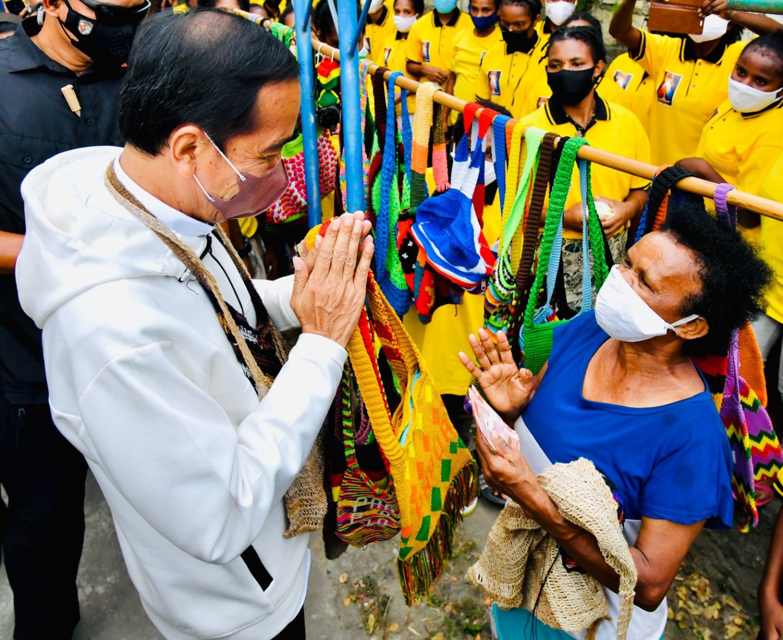 Presiden Jokowi membeli noken dari mama penjual di pinggir Jalan Raya Hawai Sentani, Jayapura, Papua.