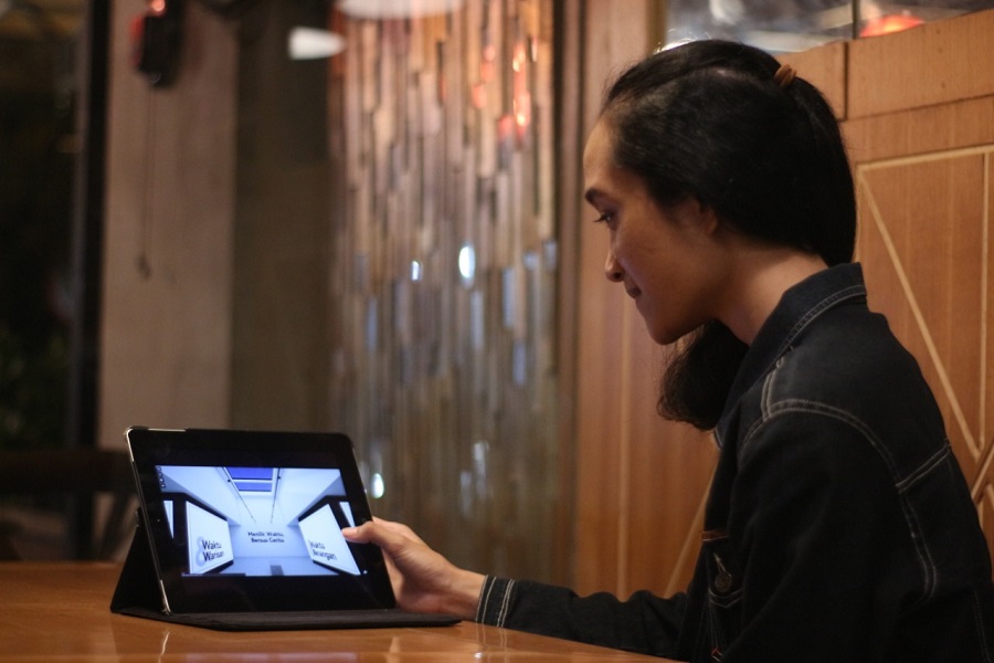 Salah satu mahasiswi UK Petra, Putru Kurnia, mengakses pameran virtual Photostory Vol. 7
