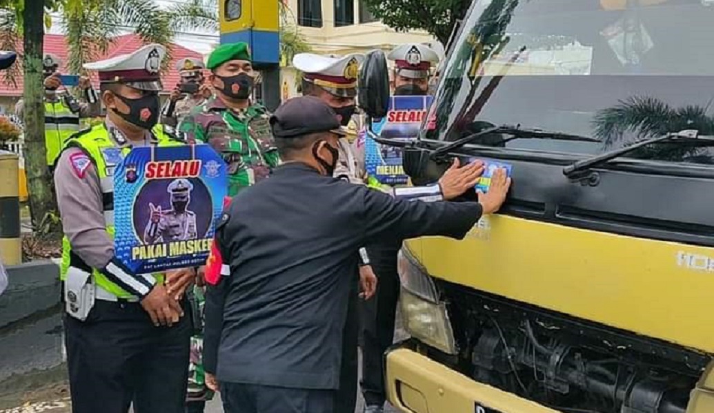 Petugas Polres Kotim melakukan penempelan stiker imbauan mematuhi Prokes, Senin (22/2).  
