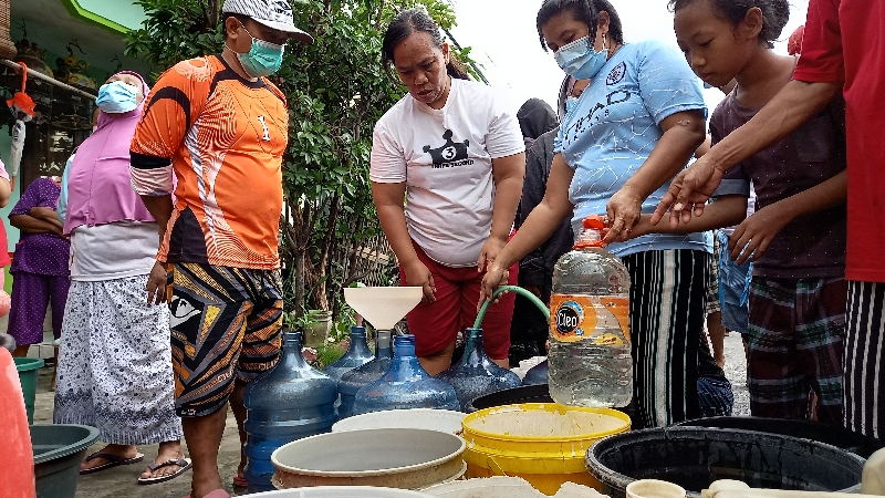 Warga Puri Lidah Kulon Surabaya saat mengantri mendapatkan air bersih, Sabtu (13/3/2021). 