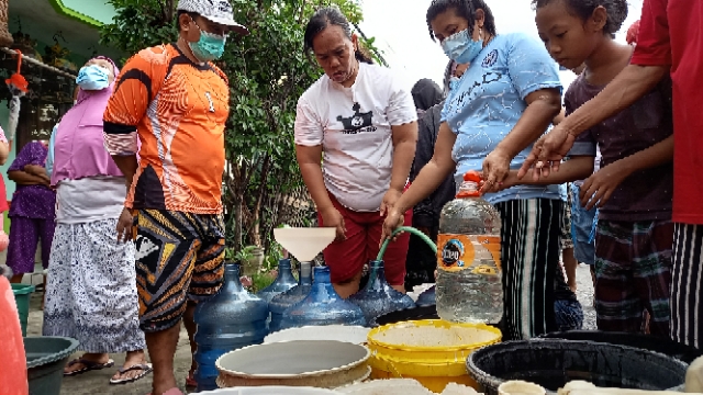 Warga Puri Lidah Kulon Surabaya saat mengantri mendapatkan air bersih, Baru-baru ini. | dok/bacasaja.id