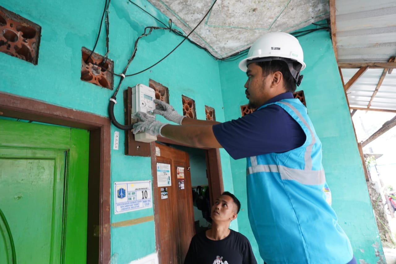 Petugas PLN melakukan penggantian kWh meter ke smart meter di salah satu rumah pelanggan