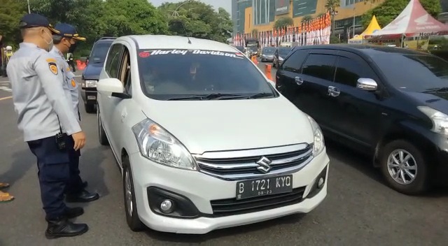 Petugas saat memeriksa pengendara mobil yang berplat selain Surabaya di titik penyekatan Bundaran Waru, Kamis (6/5). 