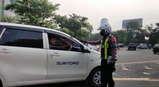 Petugas saat memeriksa pengendara mobil yang berplat selain Surabaya di titik penyekatan Bundaran Waru, Kamis (6/5/2021).