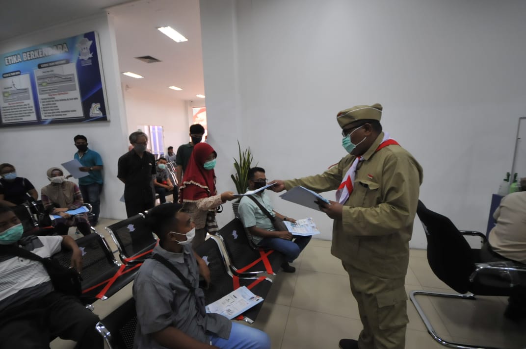 salah satu petugas satpas colombo surabaya berpakaian pejuang membagikan formulir SIM