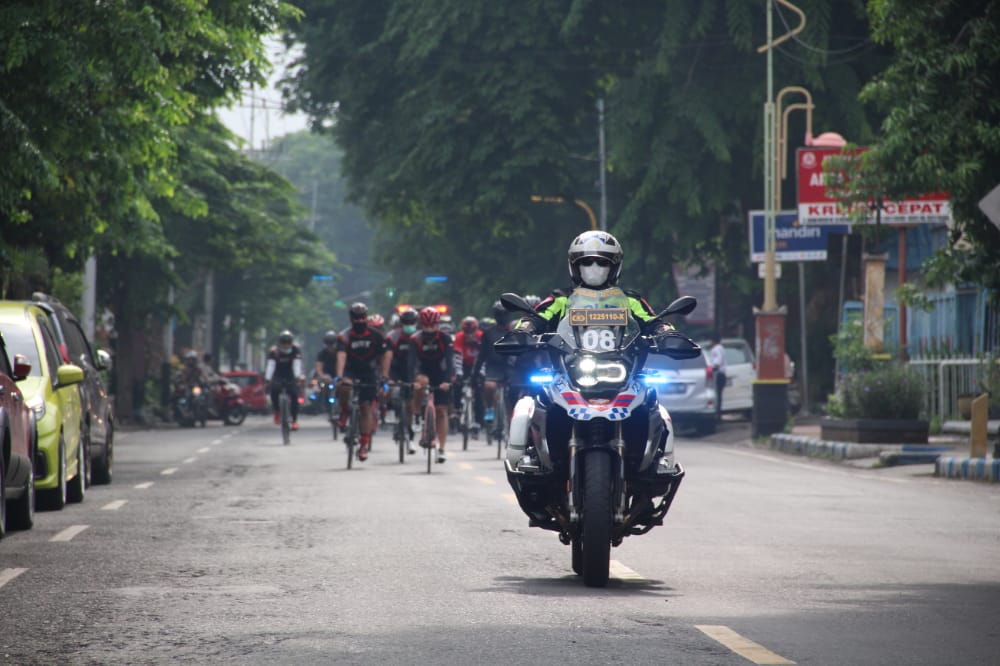 Anggota Satlantas Polresta Mojokerto mengawal peserta sepeda