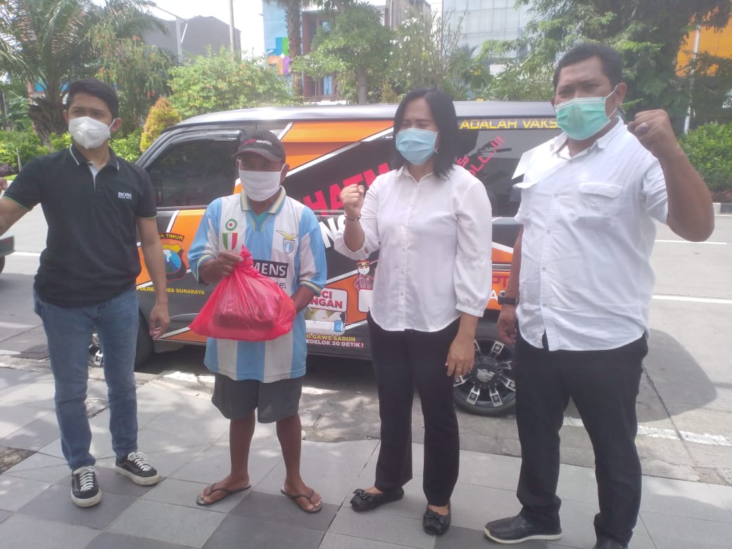 Tim Mobil Senyum dan Semangatku Polrestabes Surabaya saat mengganjar warga yang patuh prokes dengan bingkisan sembako.