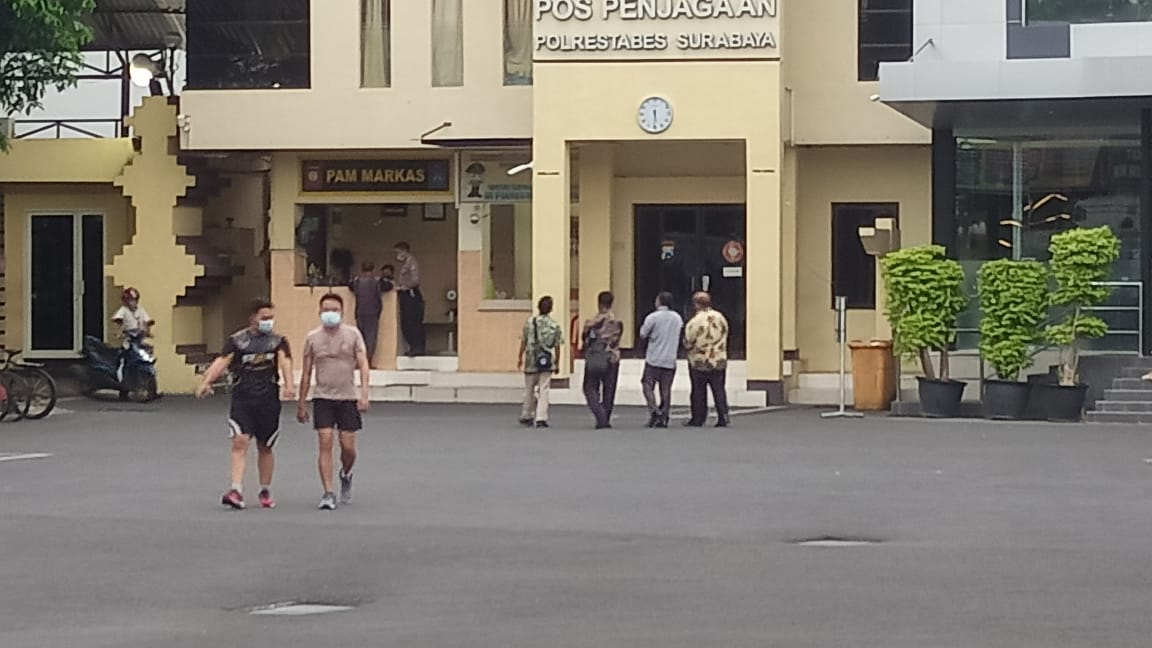Kepala Sekolah SMK Tanwir, AR (paling kiri) ditemani kuasa hukumnya berjalan keluar dari halaman Mapolrestabes Surabaya setelah menjalani pemeriksaan. (Istimewa)