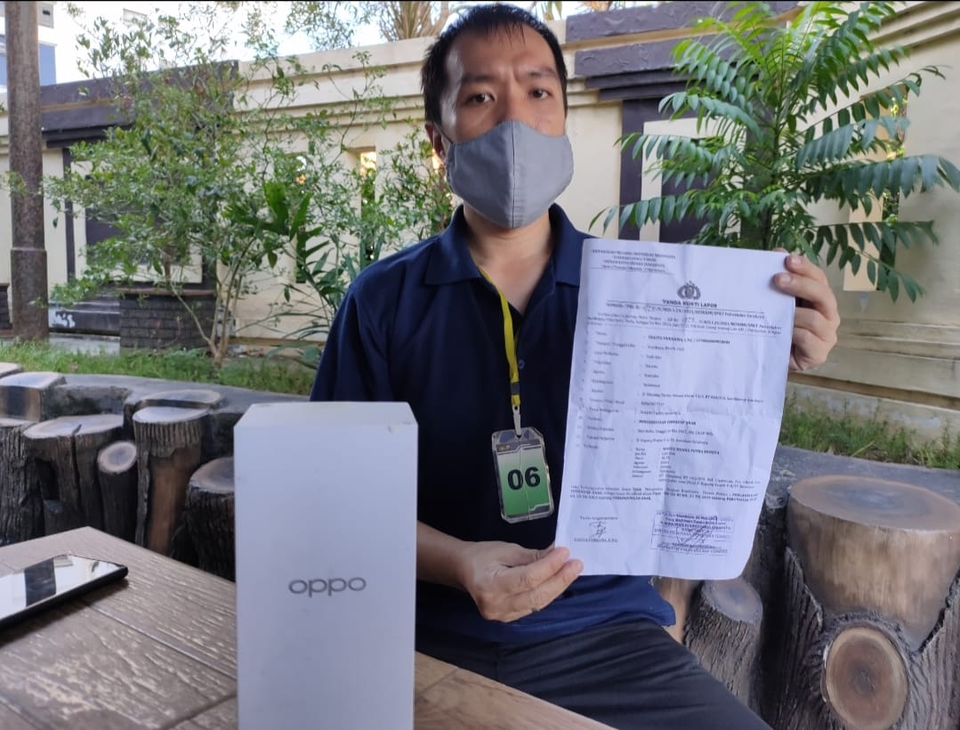 Paman korban menunjukkan bukti laporan Polisi.