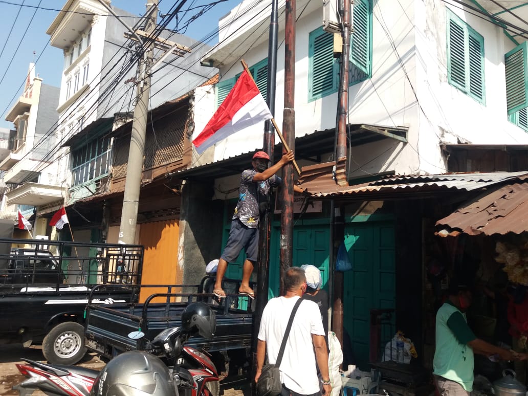 warga memasang bendera merah putih didepan rumah