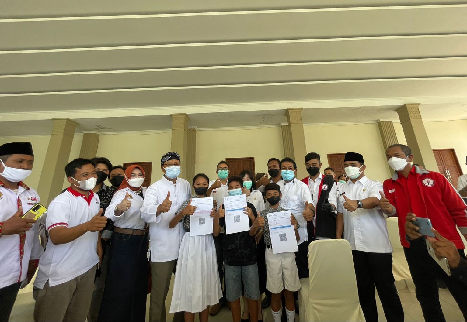 Wali Kota Pasuruan Syaifullah Yusuf, anggota TMP, Seknas Jokowi, dan JAMAN, berfoto bersama para peserta vaksinasi Covid-19 massal.