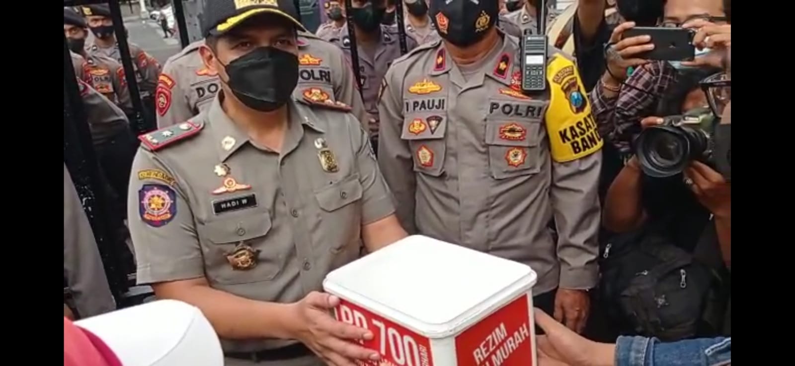 Buruh menyerahkan hasil saweran kepada Kasatpol PP Jatim M Hadi Wawan Guntoro.