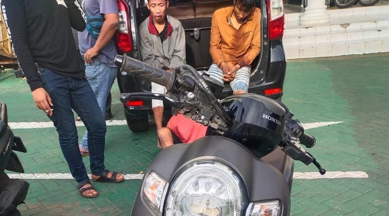 Kedua pelaku dan barang bukti sepeda motor saat diamankan polisi. 