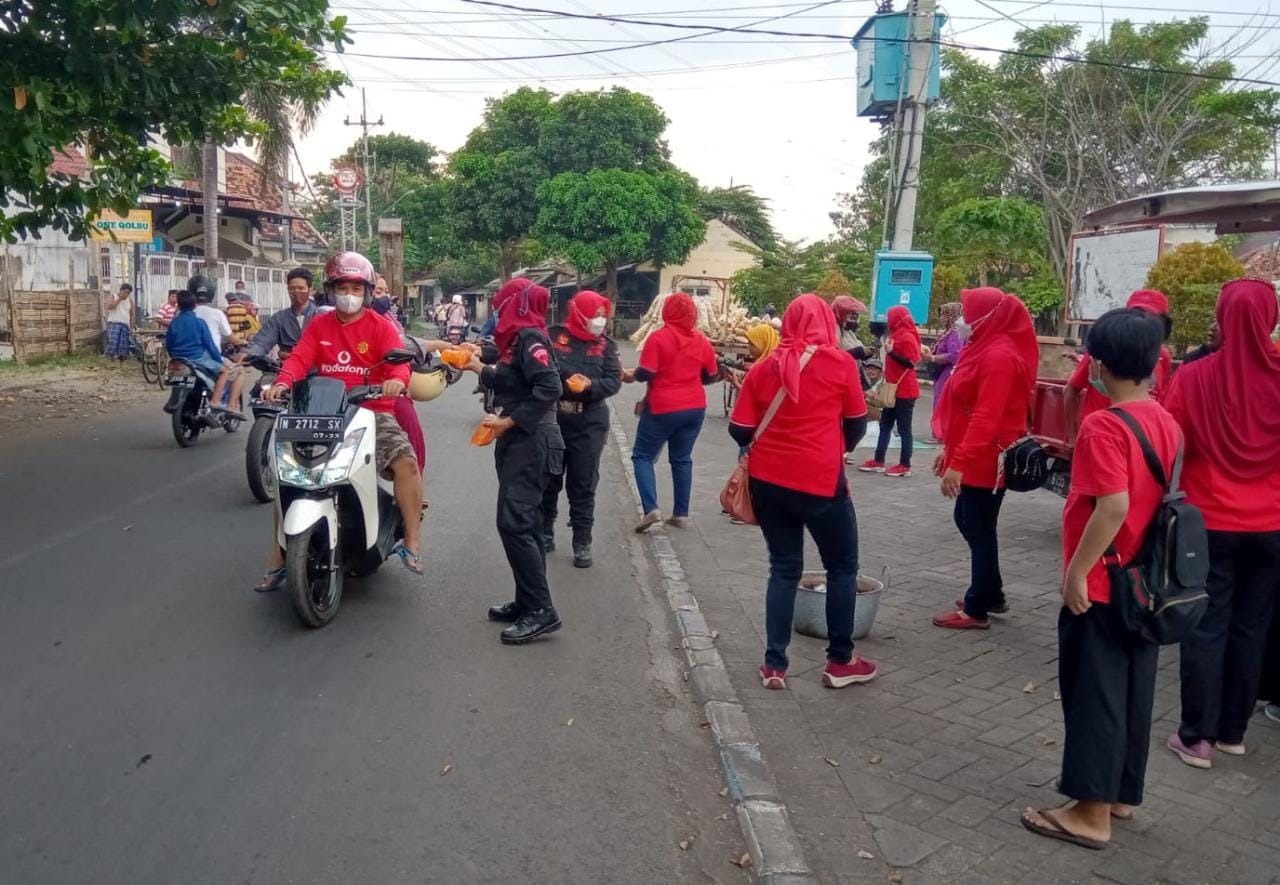 Aksi Srikandi PDI Perjuangan Kota Probolinggo yang tergabung dalam BPEK tengah membagikan puluhan takjil bagi pengendara motor.